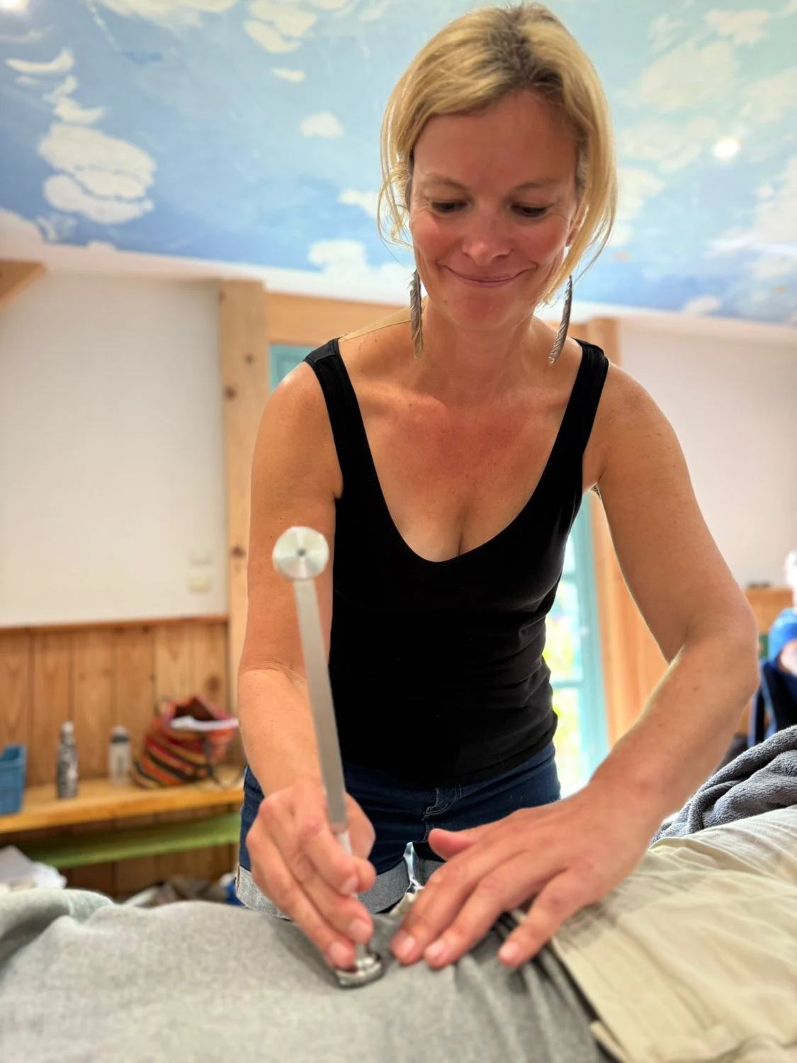 Lydia appliquant un diapason thérapeutique sur une personne habillée